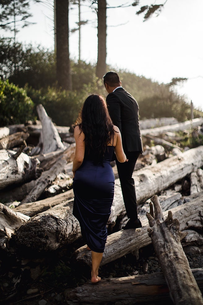 Couple walking through drift wood for Ruby Beach engagement Photoshoot