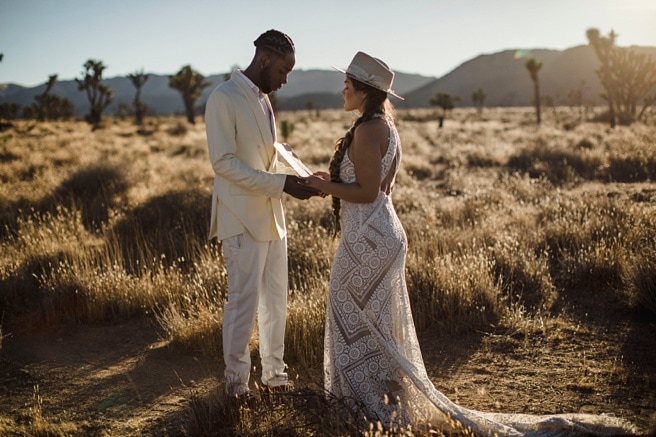 Couple saying their vows while at their desert wedding in Joshua Tree National park after purchasing their Southern California elopement package.