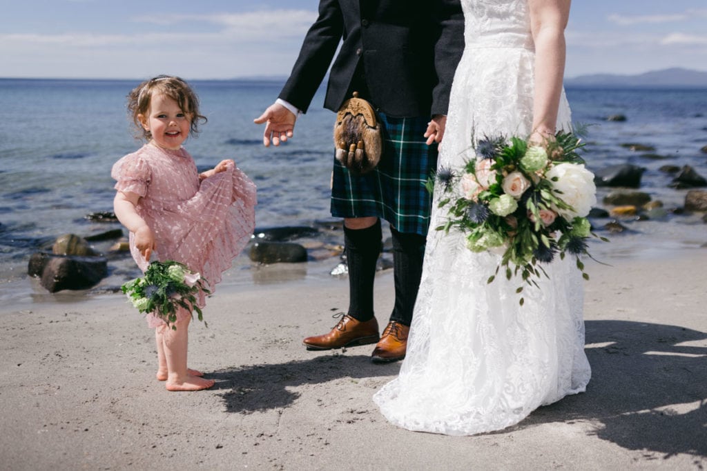 A little girl is eloping with family at the beach in Scotland.